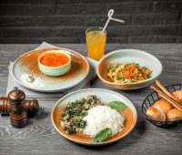 front view the first second and main dish lentil soup vegetable salad and rice with meat and juice on the table